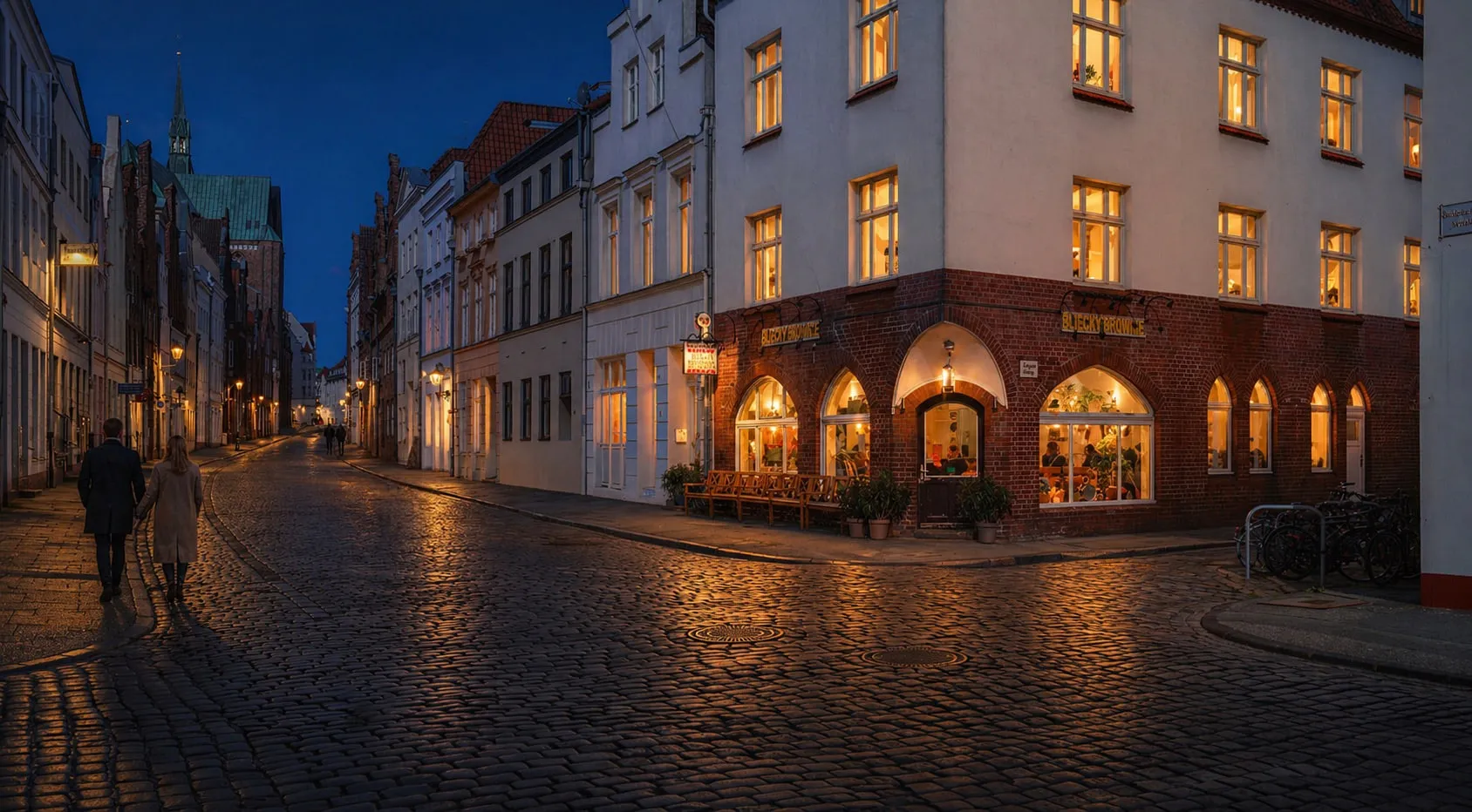 Das Restaurant Blechtrommel bei Nacht — warmes Licht aus den Fenstern, Kopfsteinpflasterstraße